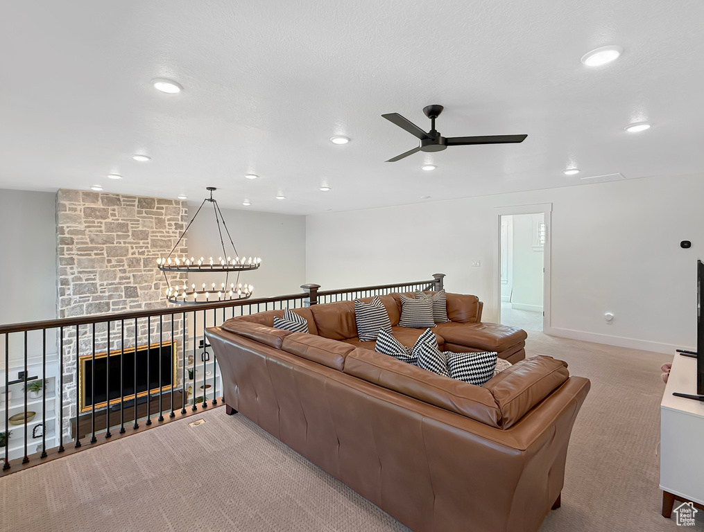 Living room with light colored carpet, ceiling fan, recessed lighting, a chandelier, and baseboards