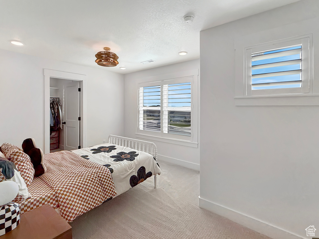 Bedroom featuring carpet flooring, baseboards, a spacious closet, and recessed lighting