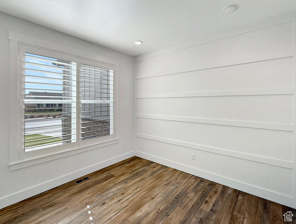 Empty room with baseboards, wood finished floors, and recessed lighting
