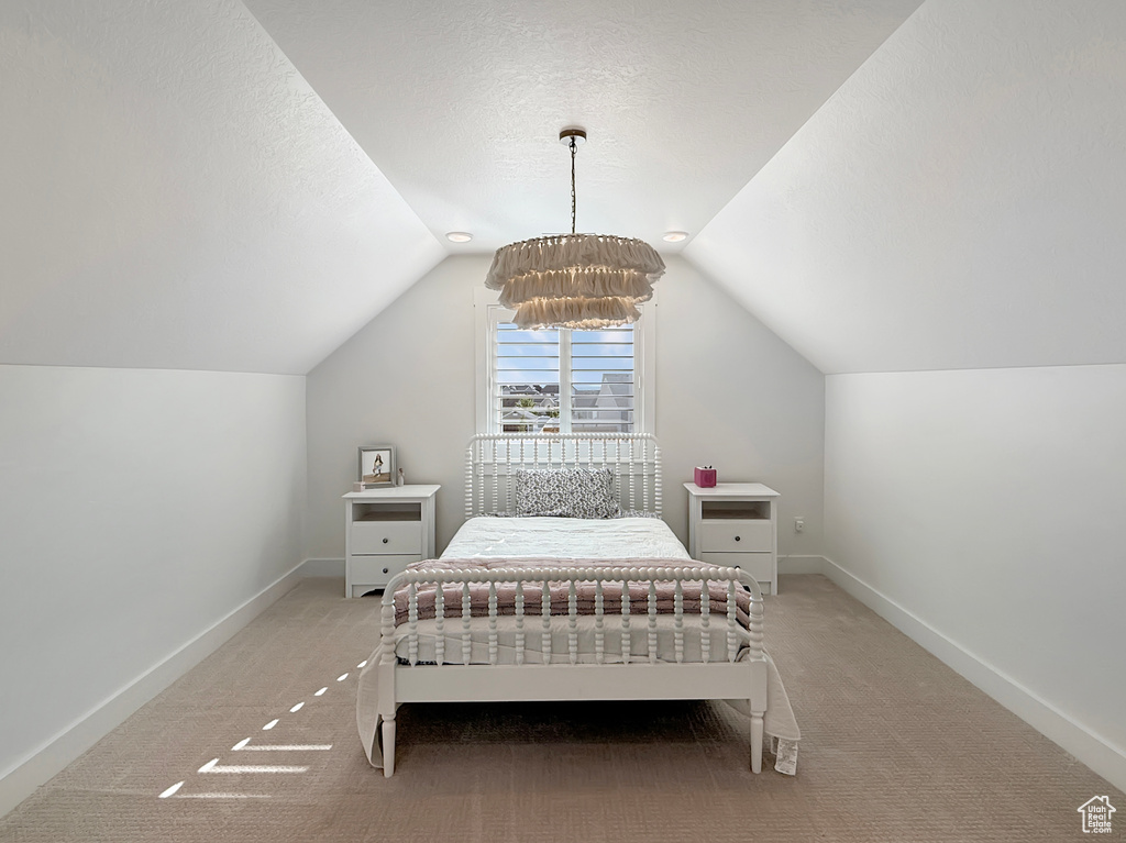 Carpeted bedroom featuring lofted ceiling, baseboards, and a textured ceiling