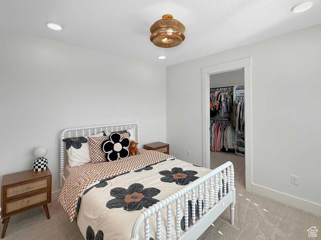 Bedroom featuring carpet, a walk in closet, a closet, and baseboards