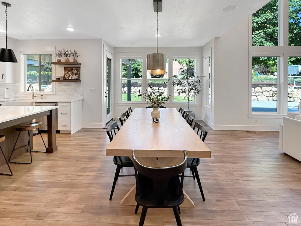 Dining area featuring light wood finished floors, baseboards, and recessed lighting