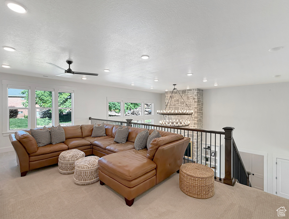 Living room featuring carpet floors, recessed lighting, a chandelier, a textured ceiling, and ceiling fan