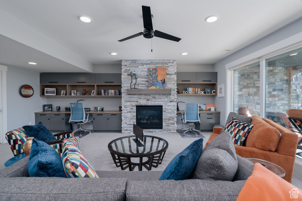 Carpeted living room with ceiling fan, recessed lighting, and a fireplace