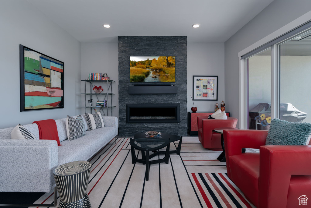Living room with a fireplace, recessed lighting, and light wood-style floors