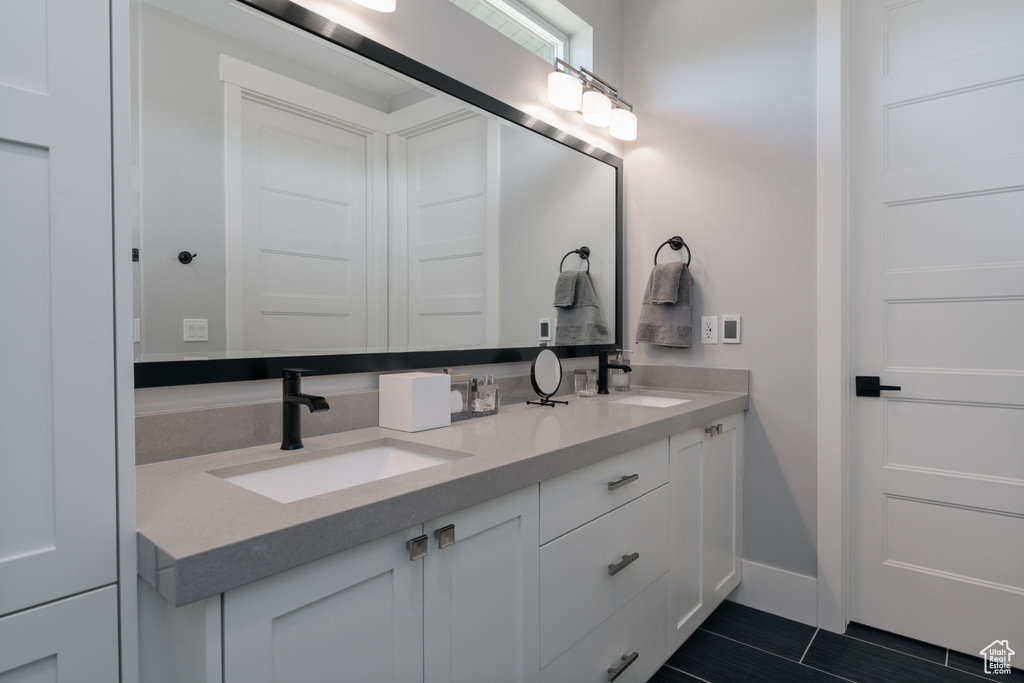 Full bath with double vanity and baseboards