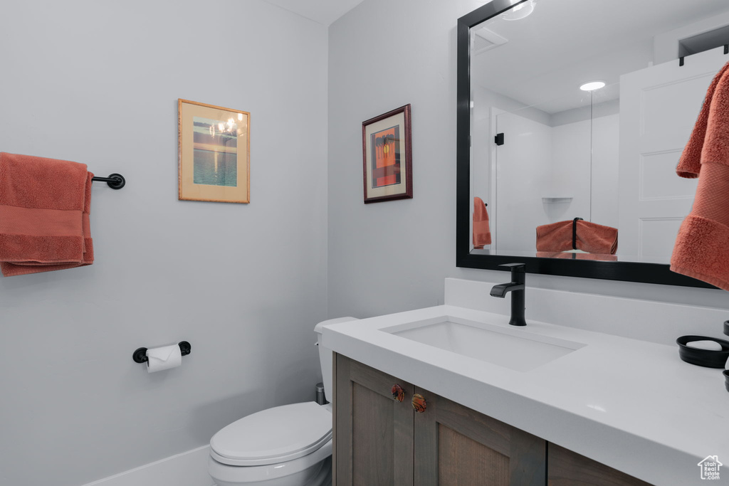Full bathroom featuring vanity, toilet, and a stall shower
