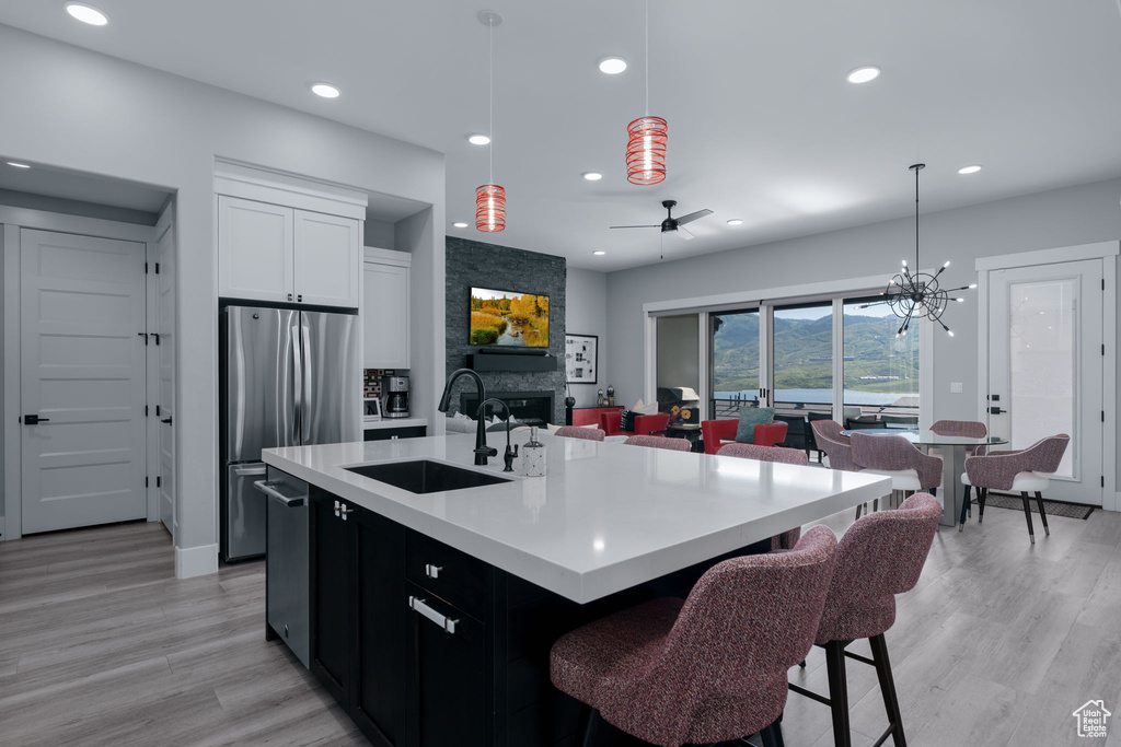 Kitchen with a sink, appliances with stainless steel finishes, recessed lighting, light wood-style flooring, and light countertops