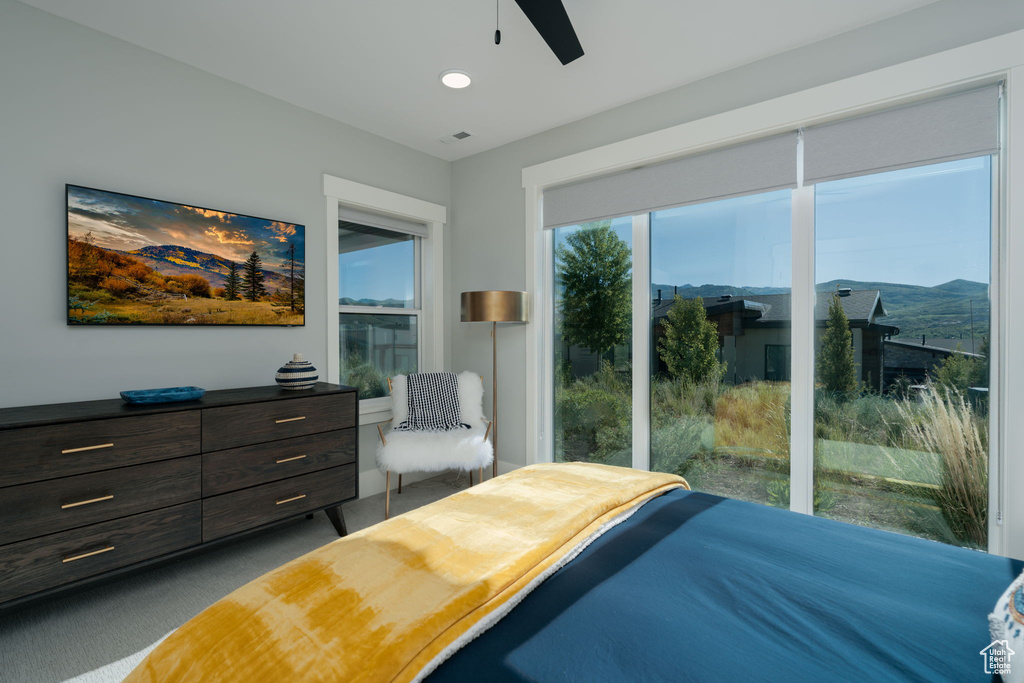 Carpeted bedroom with a ceiling fan and recessed lighting