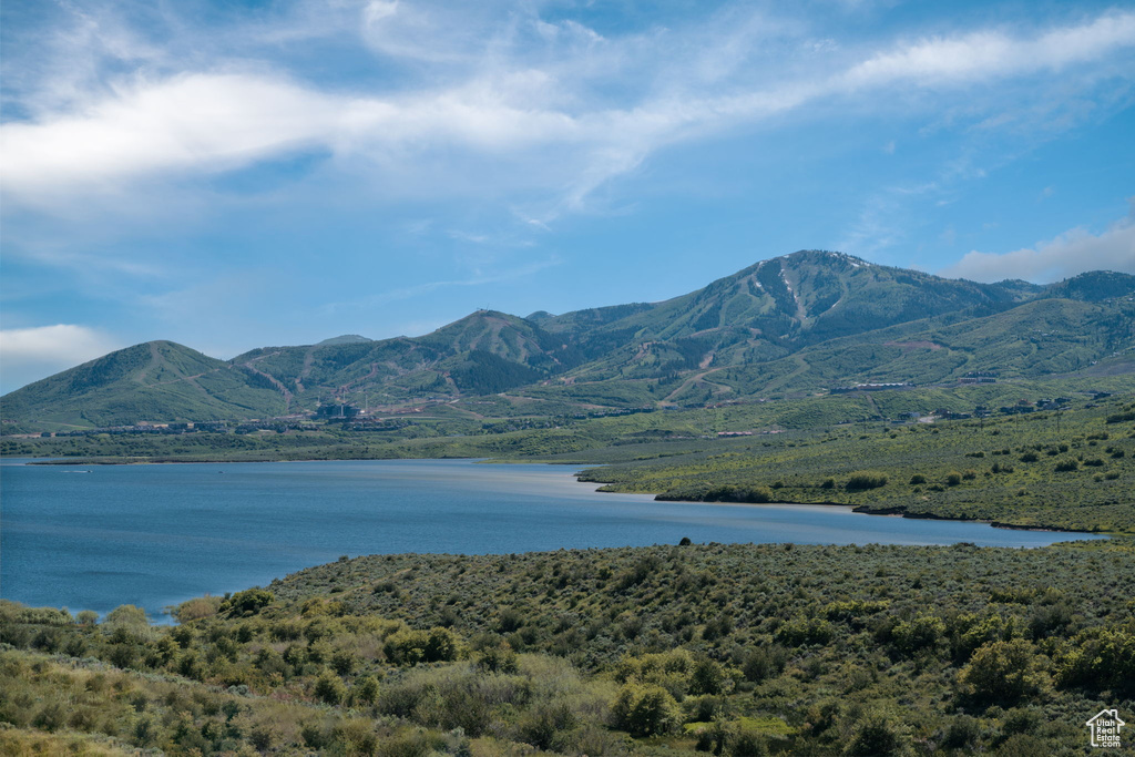 View of mountain backdrop with a nearby body of water and a forest