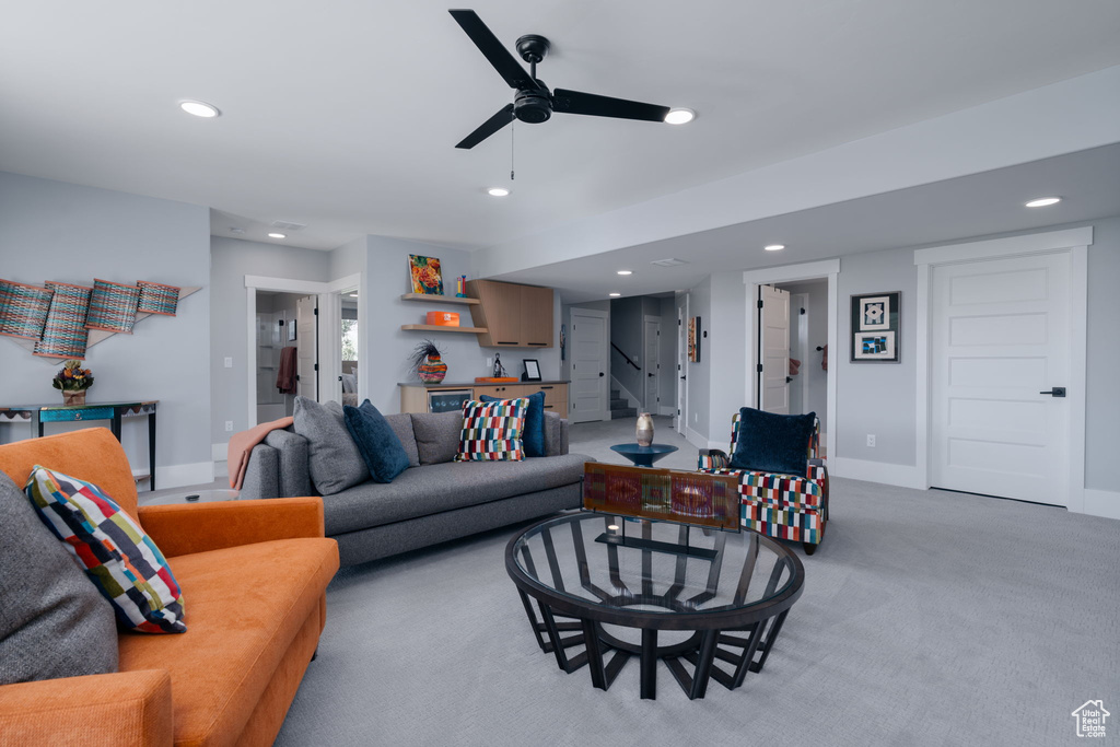 Living room with recessed lighting, light carpet, a ceiling fan, stairs, and baseboards