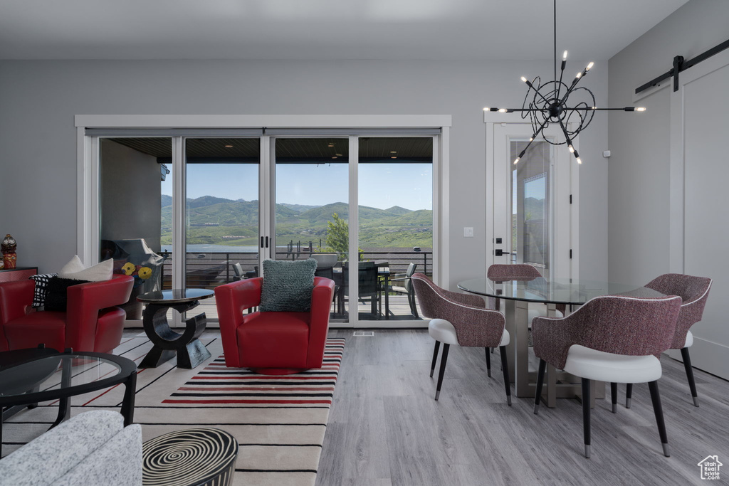 Living room with wood finished floors, a barn door, a mountain view, and healthy amount of natural light