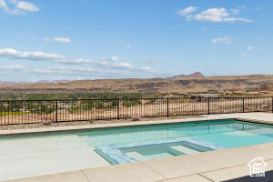 View of swimming pool featuring a pool with connected hot tub, a mountain view, and a patio