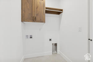 Laundry room with cabinet space, hookup for a washing machine, baseboards, and hookup for an electric dryer