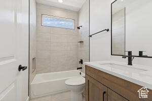 Bathroom featuring vanity, toilet, and  shower combination