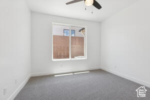 Empty room featuring a ceiling fan, carpet flooring, and baseboards