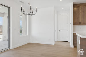 Unfurnished dining area with a chandelier, light wood-type flooring, baseboards, and recessed lighting
