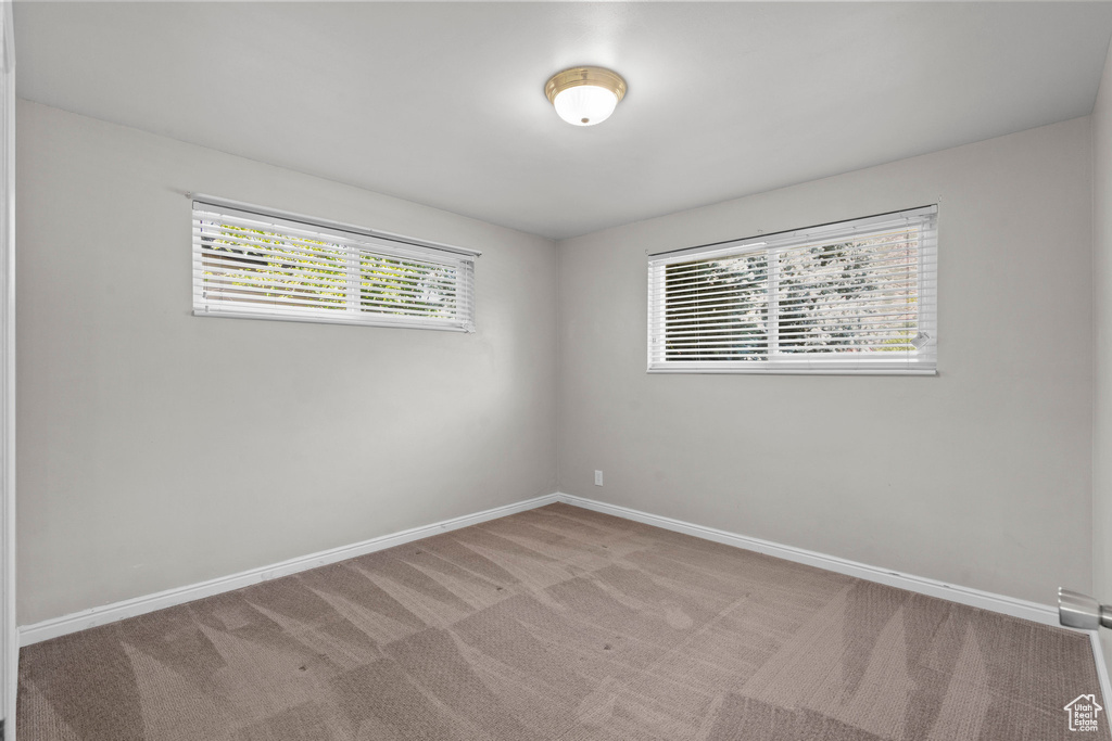 Carpeted spare room with baseboards