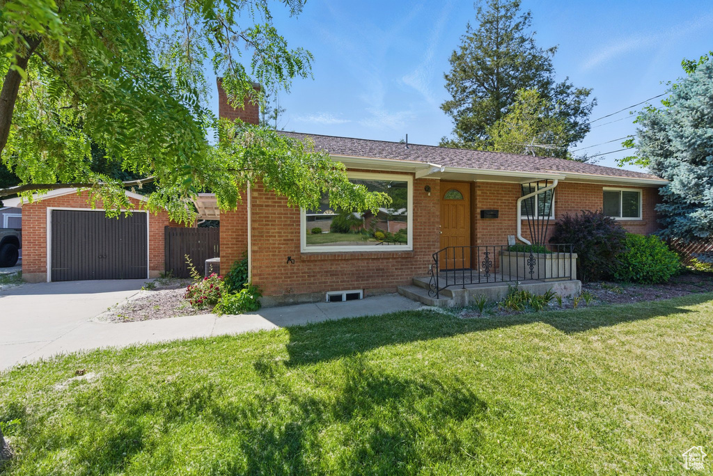 Single story home featuring a chimney, brick siding, concrete driveway, and a garage