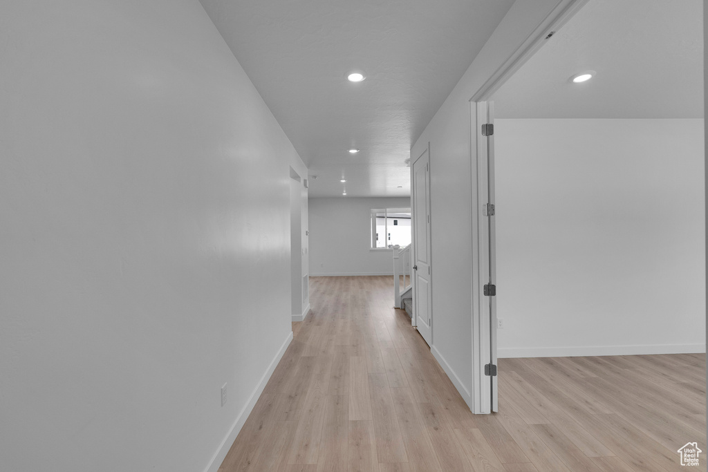 Hall featuring light wood-type flooring, recessed lighting, and baseboards