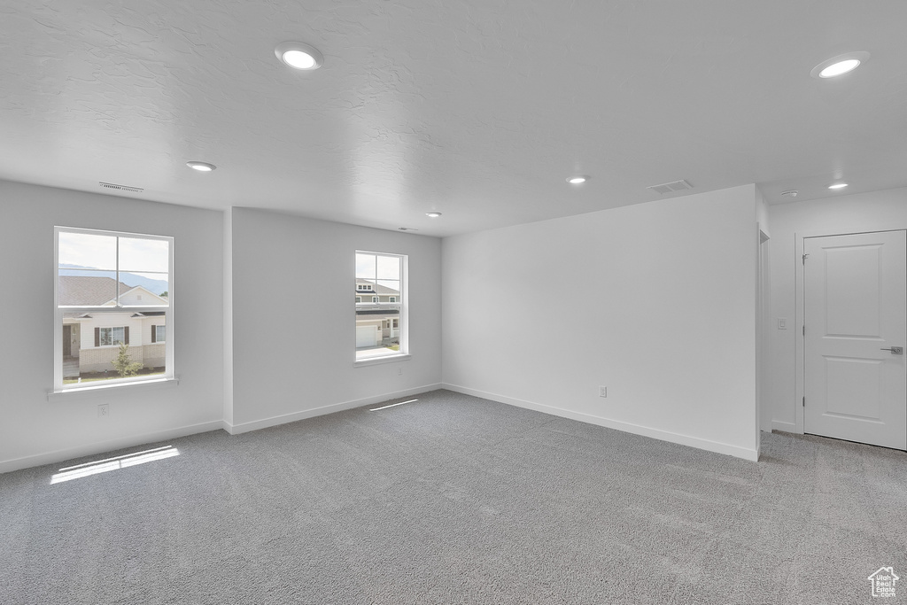 Carpeted empty room with plenty of natural light, recessed lighting, and baseboards