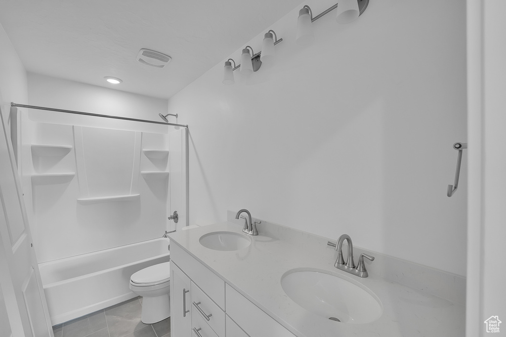 Full bath featuring bathtub / shower combination, toilet, and double vanity