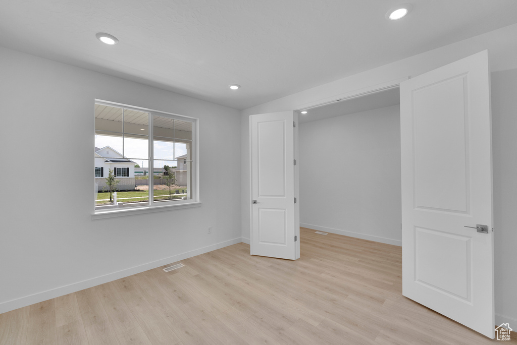 Unfurnished bedroom with light wood finished floors, baseboards, and recessed lighting