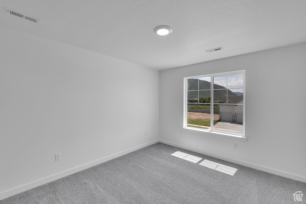 Carpeted spare room with baseboards