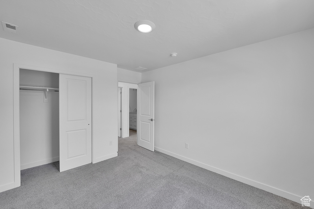 Unfurnished bedroom with carpet, baseboards, and a closet