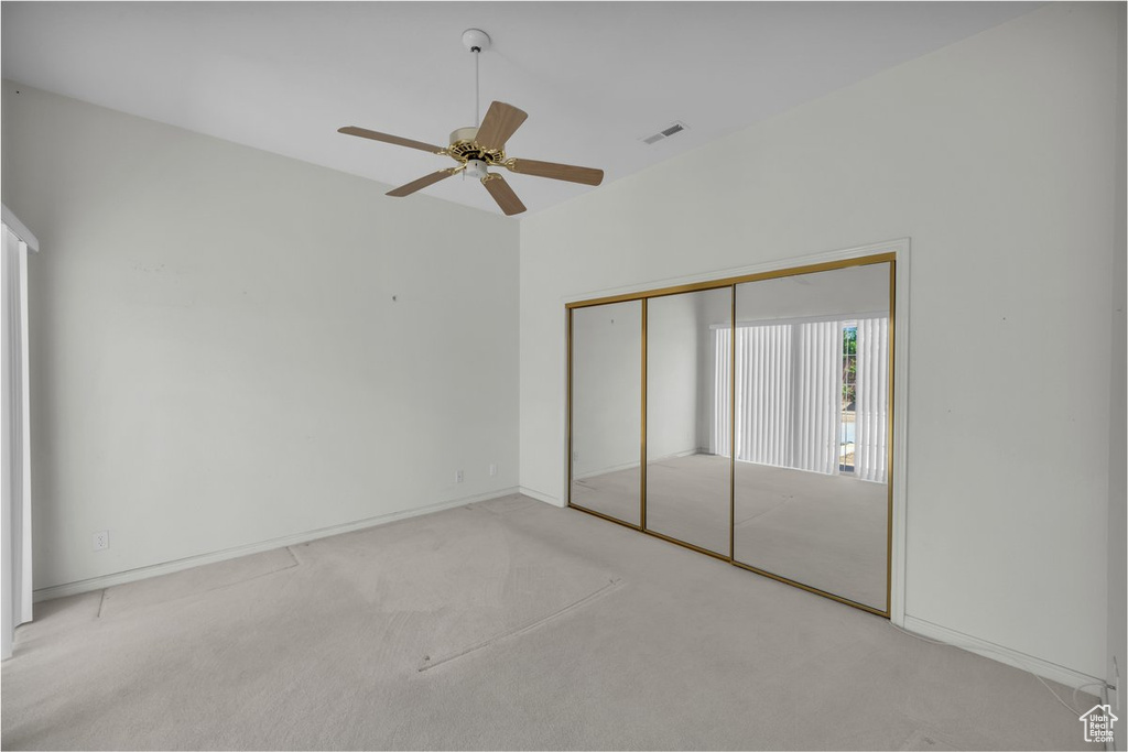 Unfurnished bedroom with carpet, a closet, ceiling fan, and baseboards