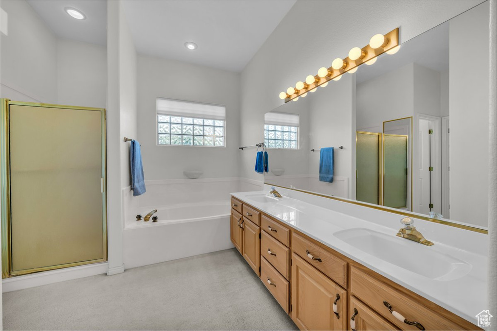 Full bathroom featuring a shower stall, double vanity, a bath, and recessed lighting