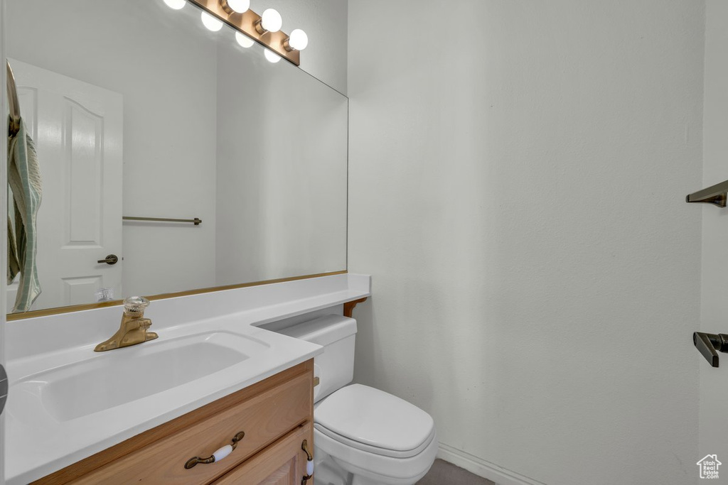 Half bathroom featuring vanity and toilet