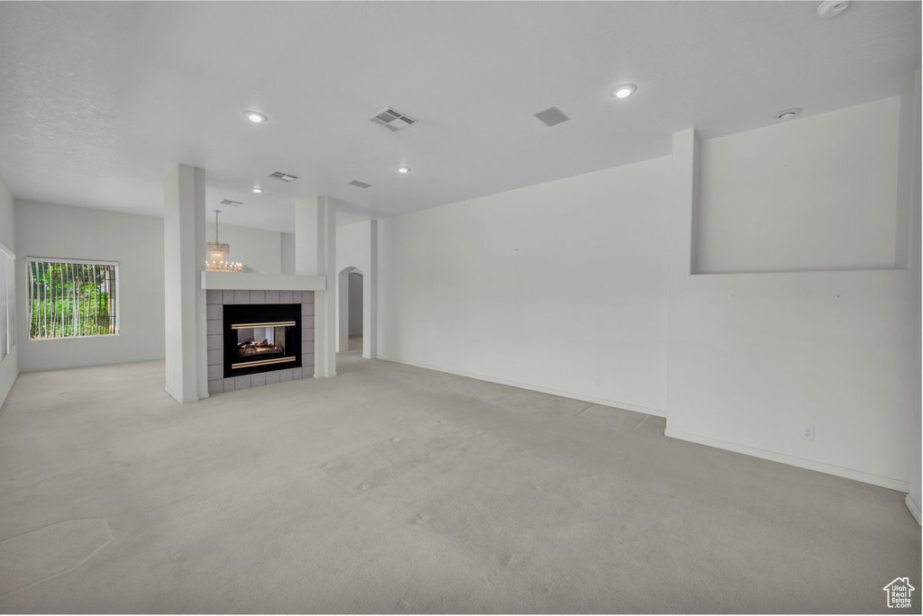 Unfurnished living room featuring carpet floors, a tile fireplace, and recessed lighting