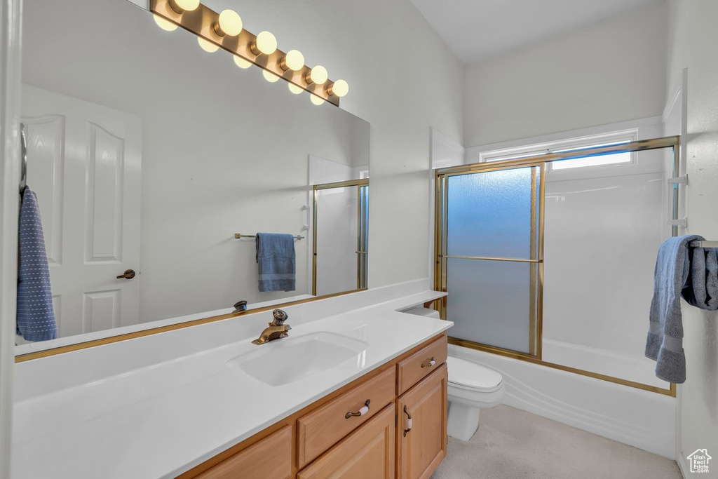 Full bath with vanity, toilet, and enclosed tub / shower combo