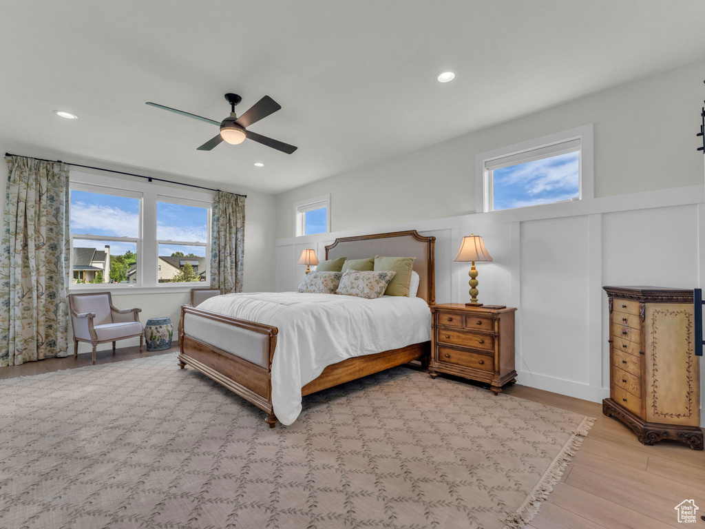 Bedroom featuring wood finished floors, a ceiling fan, recessed lighting, and wainscoting