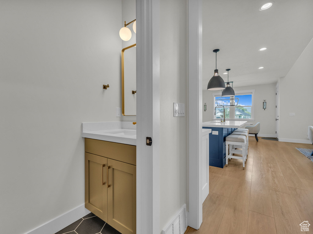 Bathroom featuring vanity, recessed lighting, baseboards, and wood finished floors