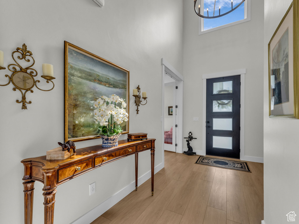 Foyer featuring a high ceiling, wood finished floors, and baseboards