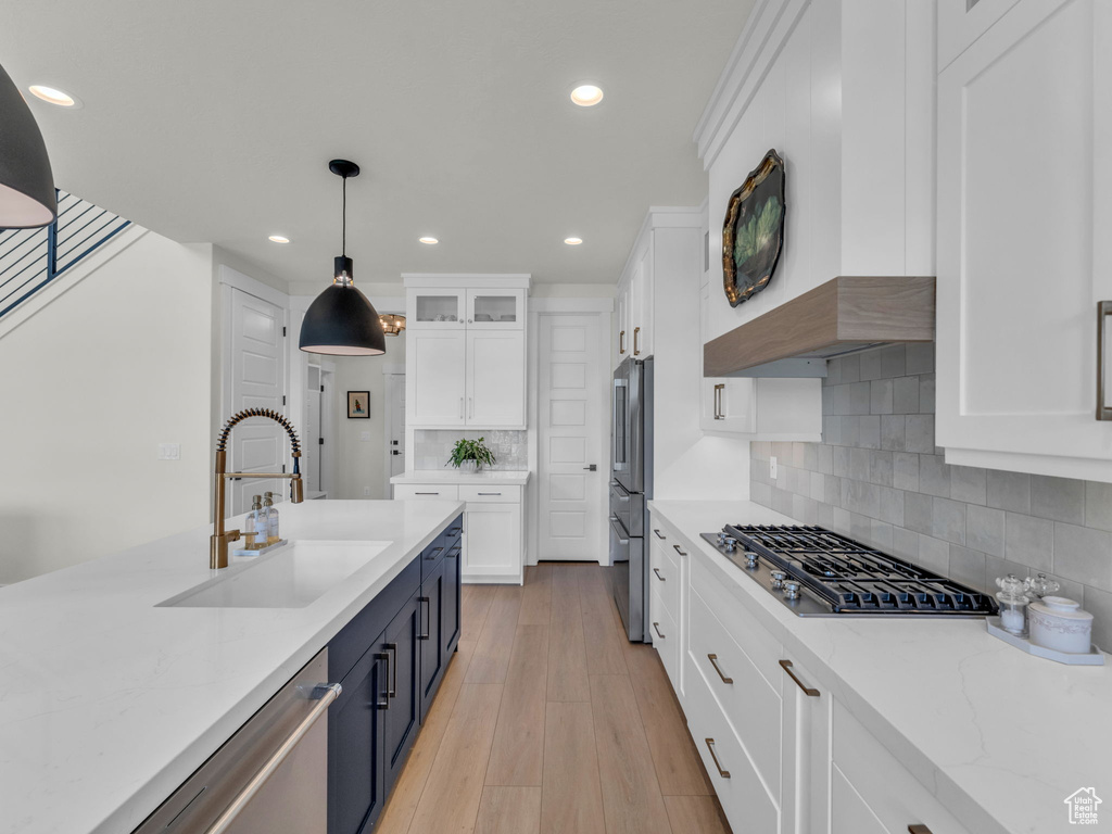 Kitchen with a sink, appliances with stainless steel finishes, white cabinetry, pendant lighting, and recessed lighting
