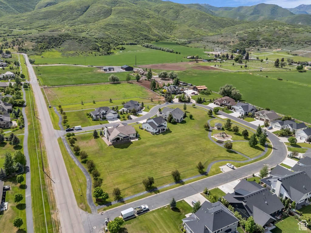 Aerial overview of property\'s location featuring a mountainous background, nearby suburban area, and rural landscape