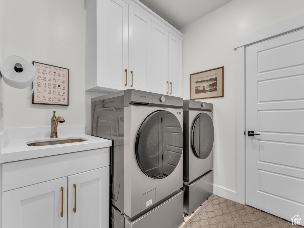Laundry room featuring washer and clothes dryer and cabinet space