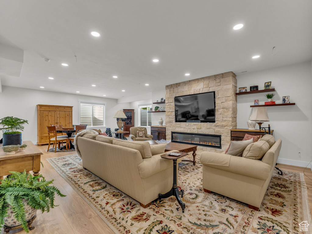 Living area featuring light wood finished floors, a fireplace, and recessed lighting