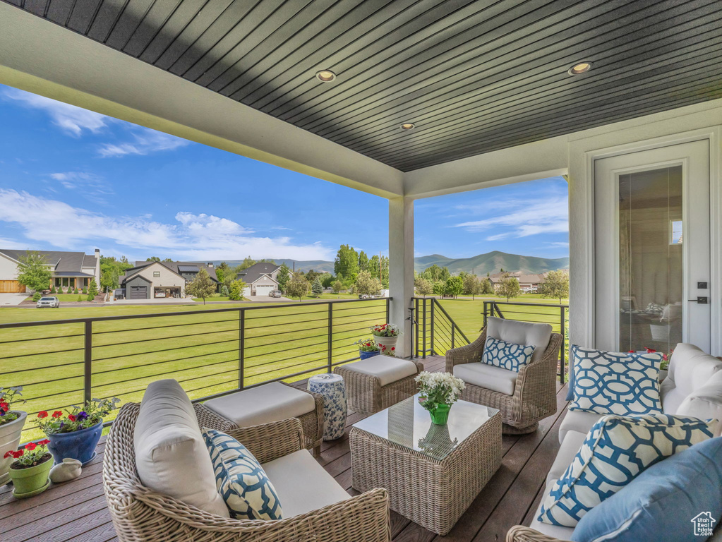 Wooden deck featuring outdoor lounge area, a mountain view, and a yard