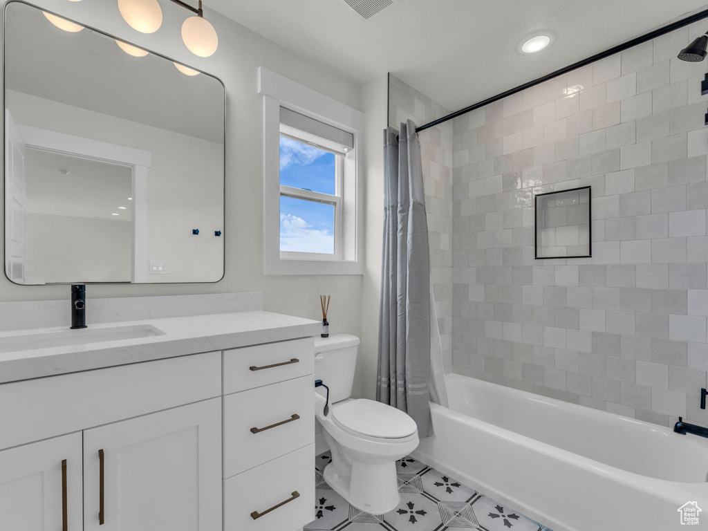 Full bathroom with tile patterned flooring, toilet, vanity, shower / bath combo, and recessed lighting