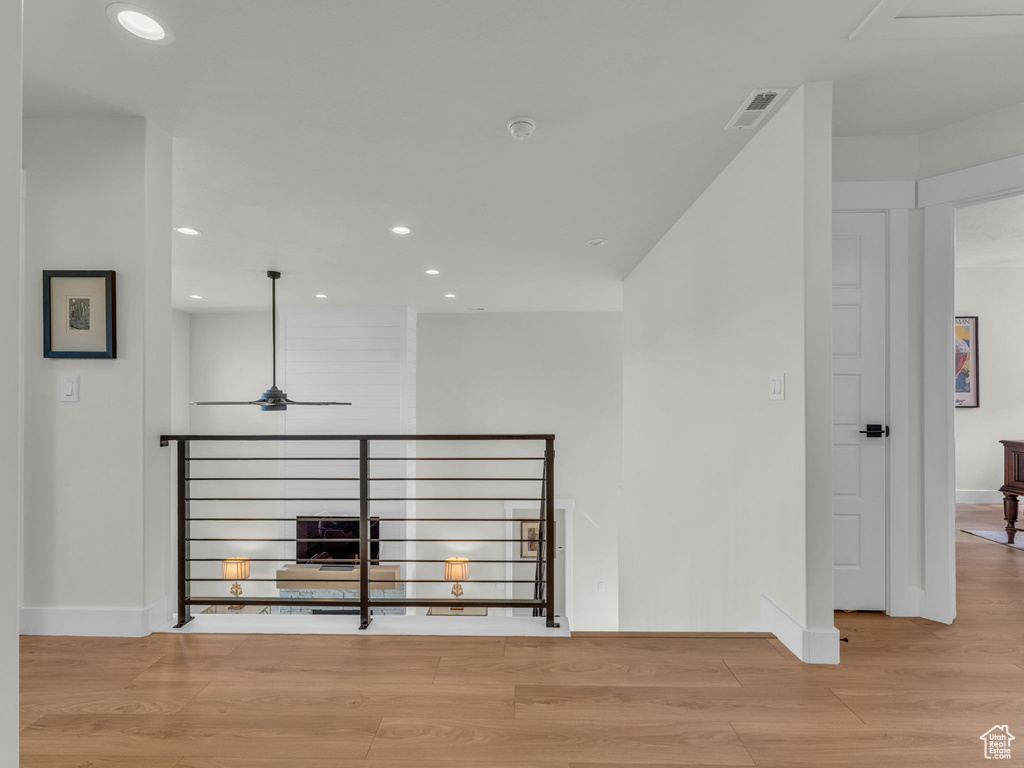 Corridor featuring wood finished floors, recessed lighting, baseboards, and an upstairs landing