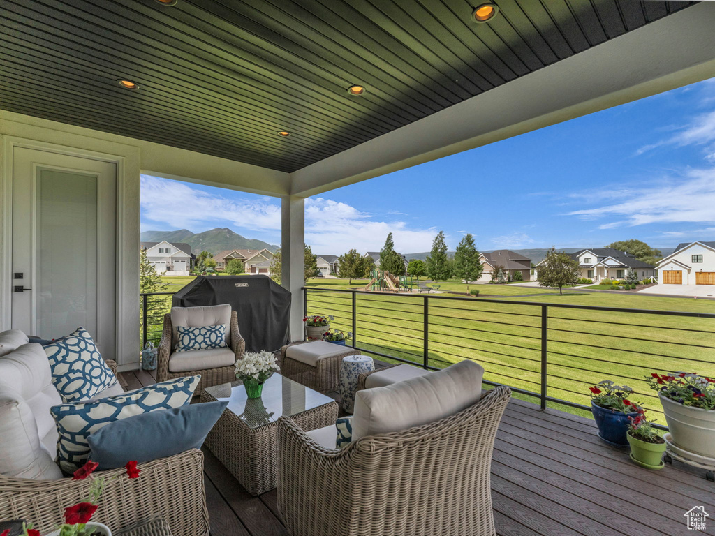 Wooden deck with a residential view, an outdoor living space, and a lawn
