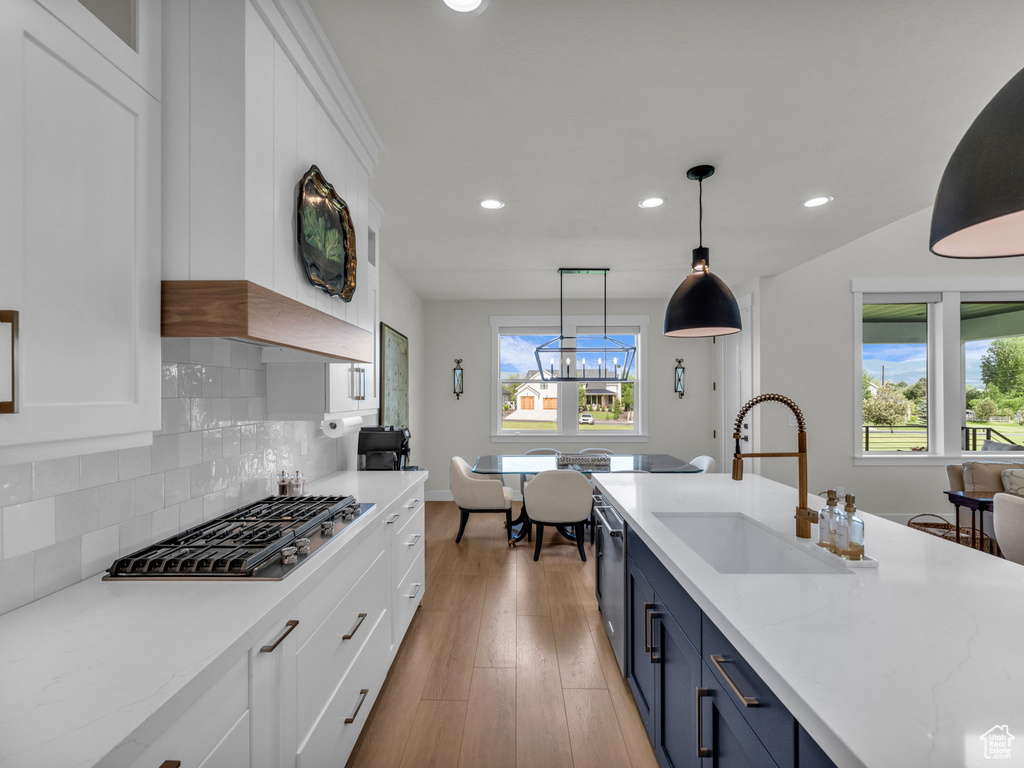 Kitchen featuring blue cabinetry, stainless steel appliances, a sink, recessed lighting, and white cabinetry
