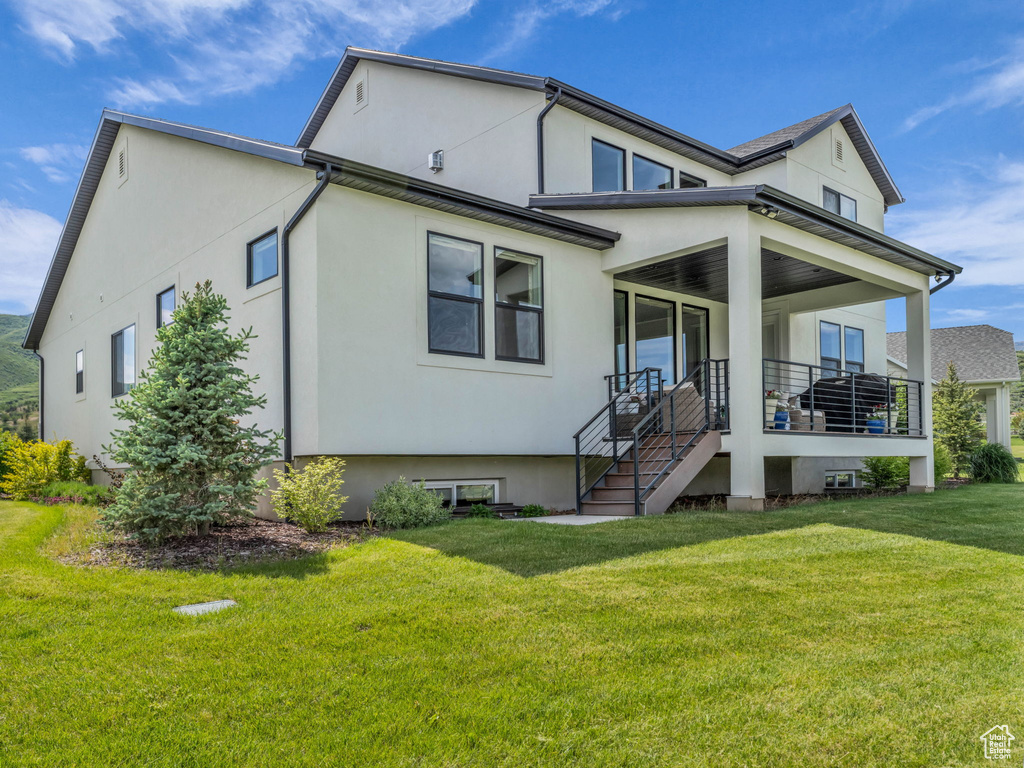 View of front of home with a front lawn, stucco siding, and a porch