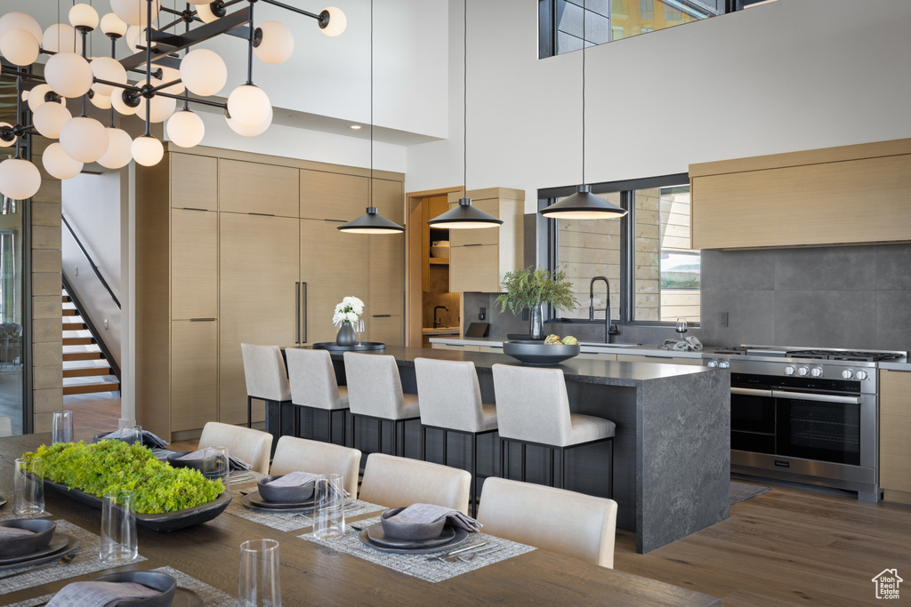 Kitchen featuring modern cabinets, oven, a sink, wood finished floors, and a center island