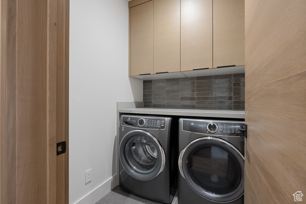 Laundry room with cabinet space, independent washer and dryer, and baseboards