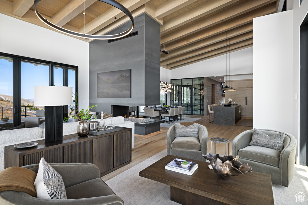 Living area with wood finished floors, high vaulted ceiling, and wood ceiling with exposed beams